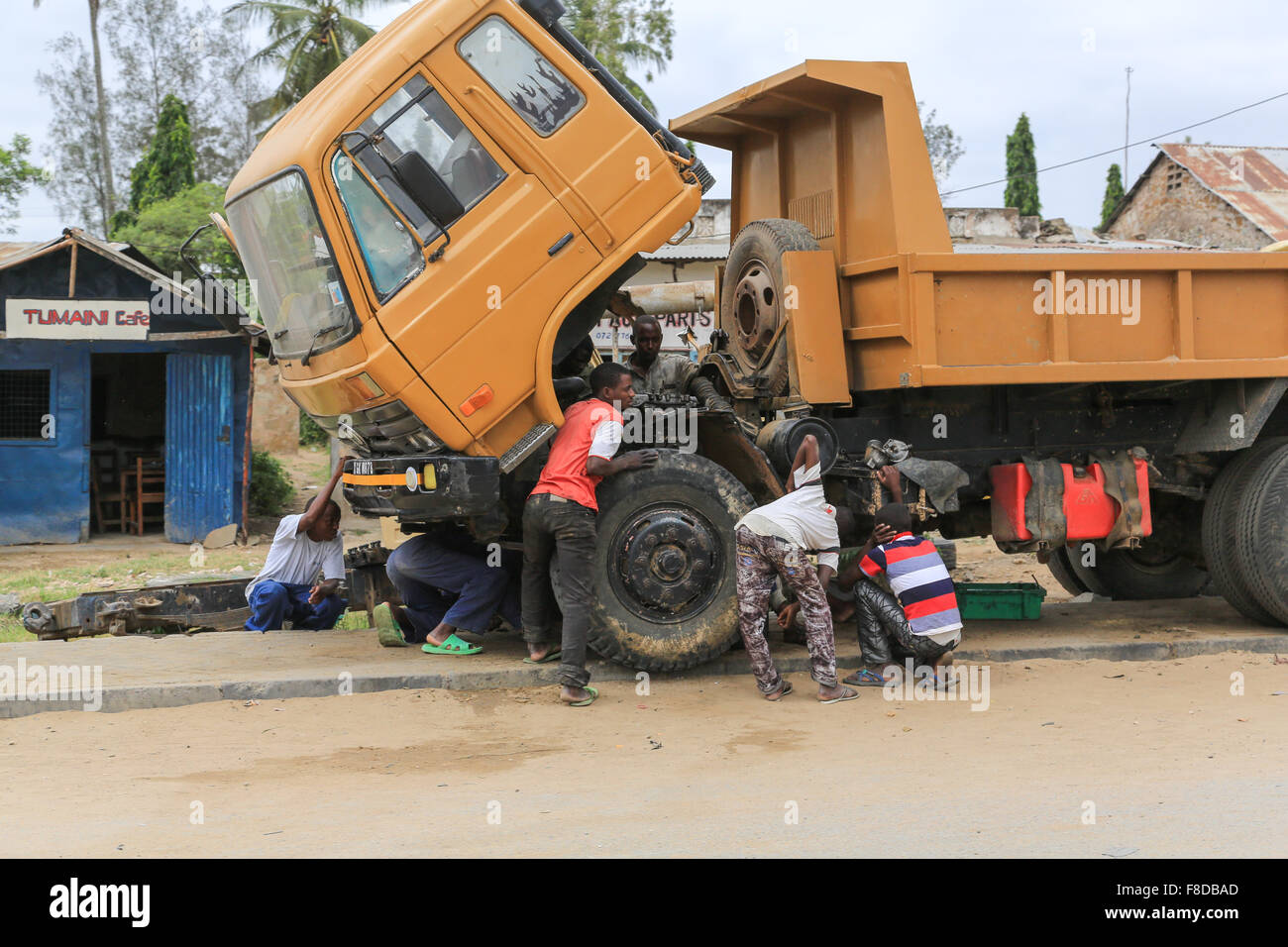 Acht Männer sind um eine unterteilt LKW entlang Mombasa Road, Mariakani, Kilifi Provinz, Kenia, Afrika kauerte. Stockfoto
