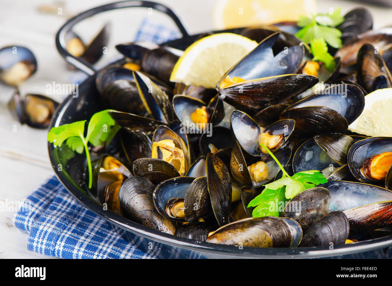 Kupferkessel von Muscheln mit Zitrone und Kräutern garniert. Selektiven Fokus Stockfoto