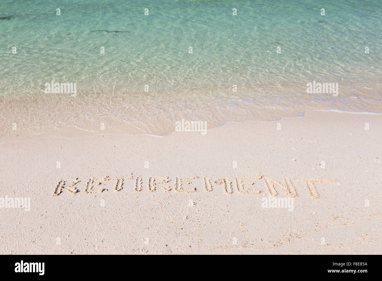 Ruhestand, Wort ausgeschrieben im nassen Sand an einem tropischen Strand in Thailand Stockfoto