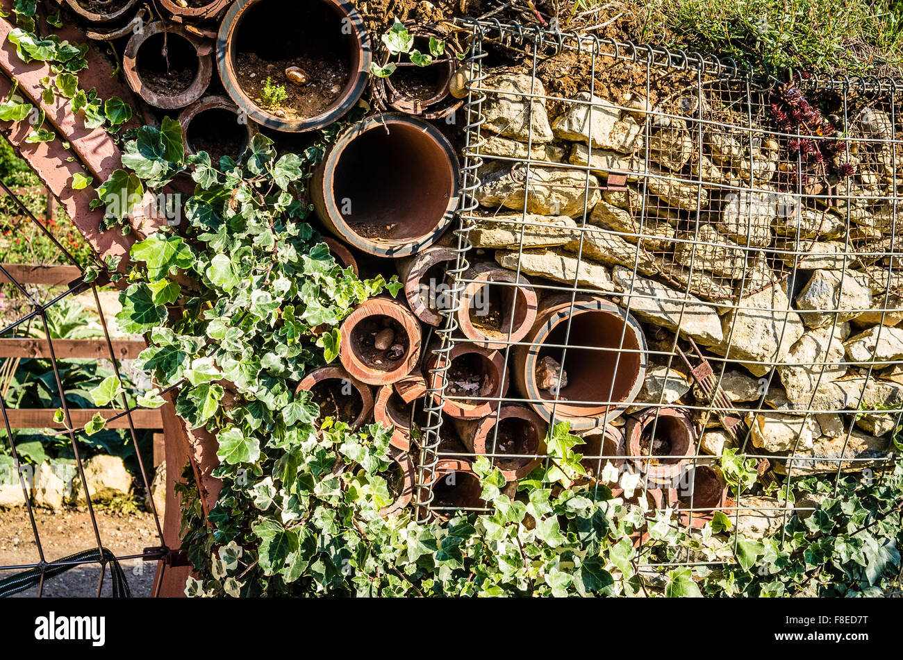 Inländische recycelt und Bauschutt Recycling zum Einsatz als zurückhaltende Mauer in einem Garten mit Gefäßen, die Bereitstellung von Wohnungen für Insekten und Tiere Stockfoto