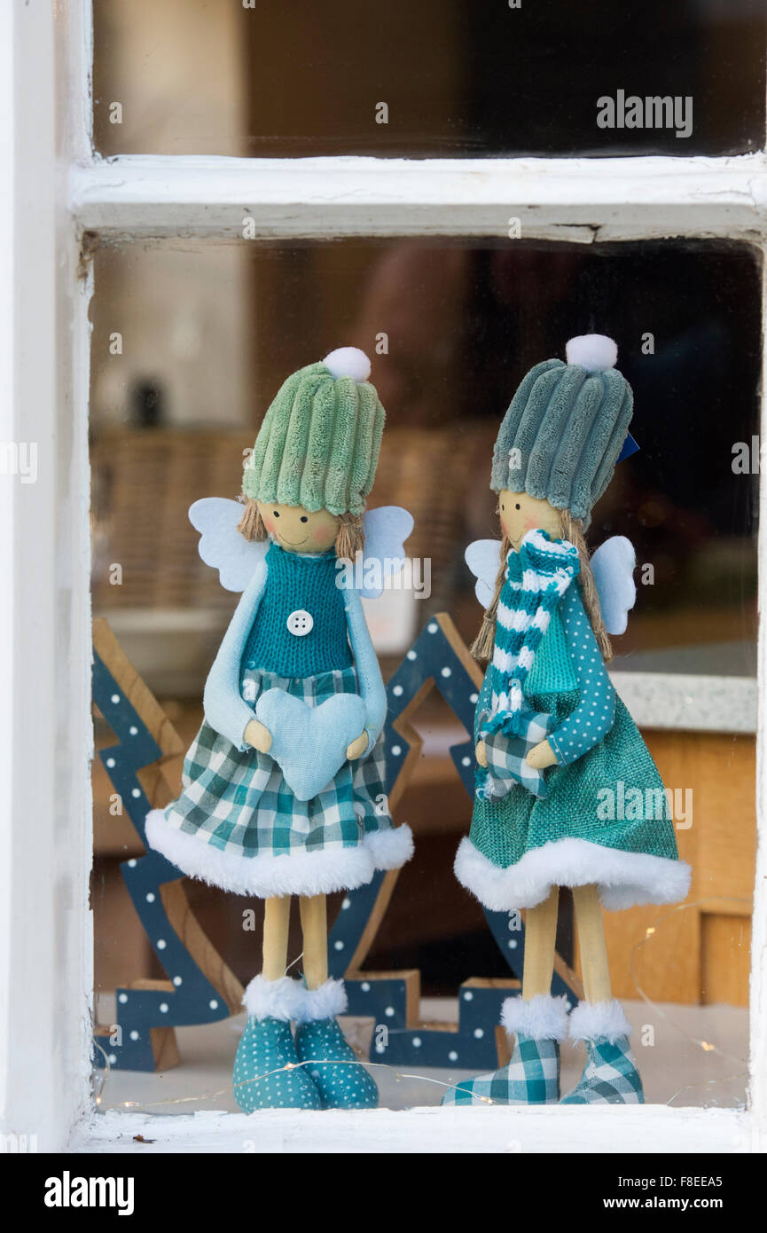 Zwei Weihnachtsengel Puppen in einem Schaufenster. Cotswolds, England Stockfoto
