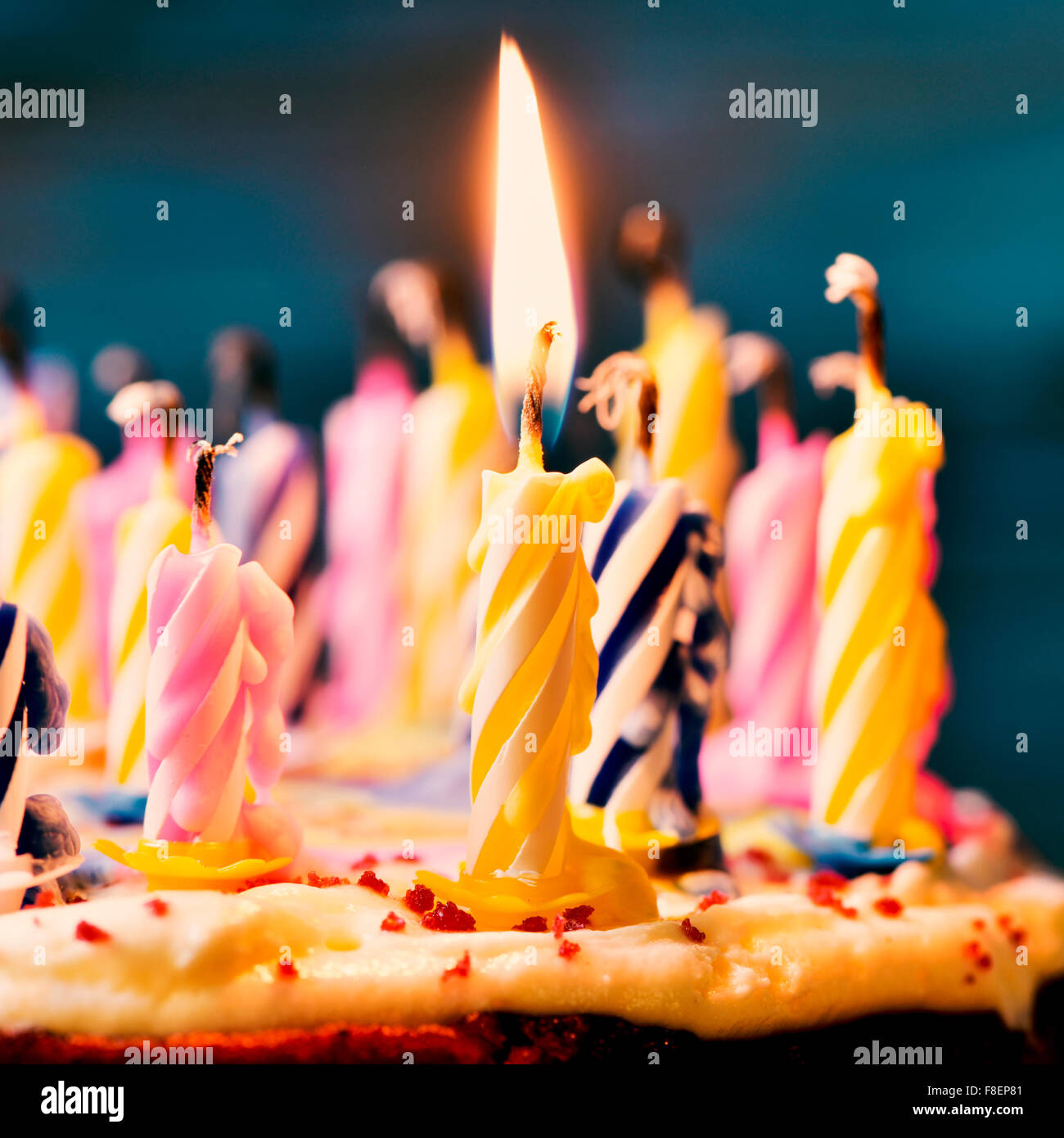 Nahaufnahme von einigen unbeleuchtet Kerzen und nur eine brennende Kerze  nach dem Ausblasen des Kuchens, gefiltert Stockfotografie - Alamy