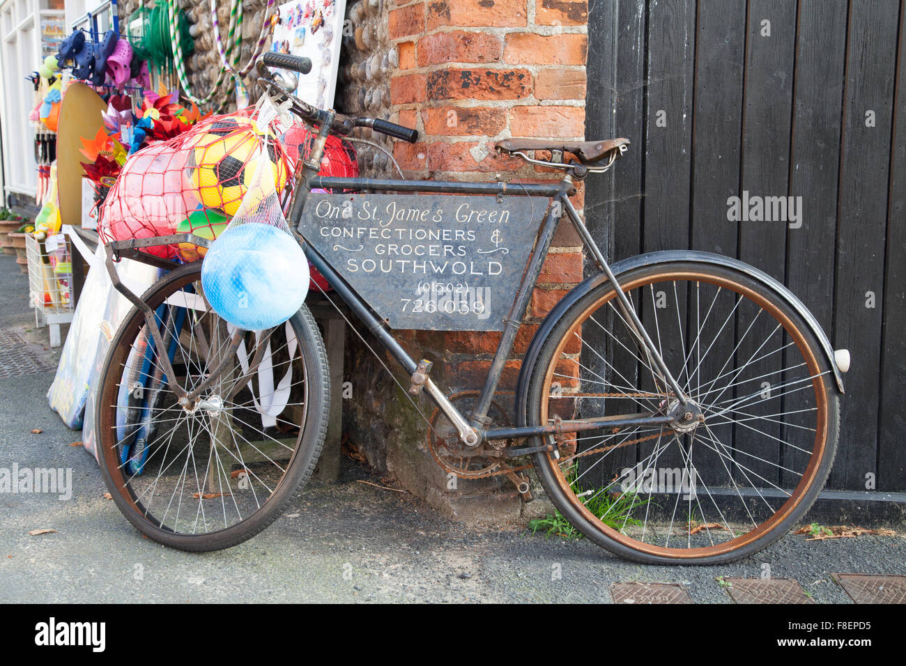 Alten Austräger schwarzes Fahrrad verwendet als Werbung Merkmal außerhalb ein Lebensmittelgeschäft in Southwold, Suffolk England Stockfoto