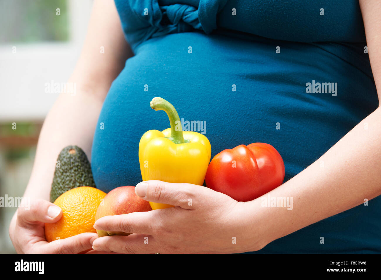 Schwangere Frau mit Obst und Gemüse hautnah Stockfoto