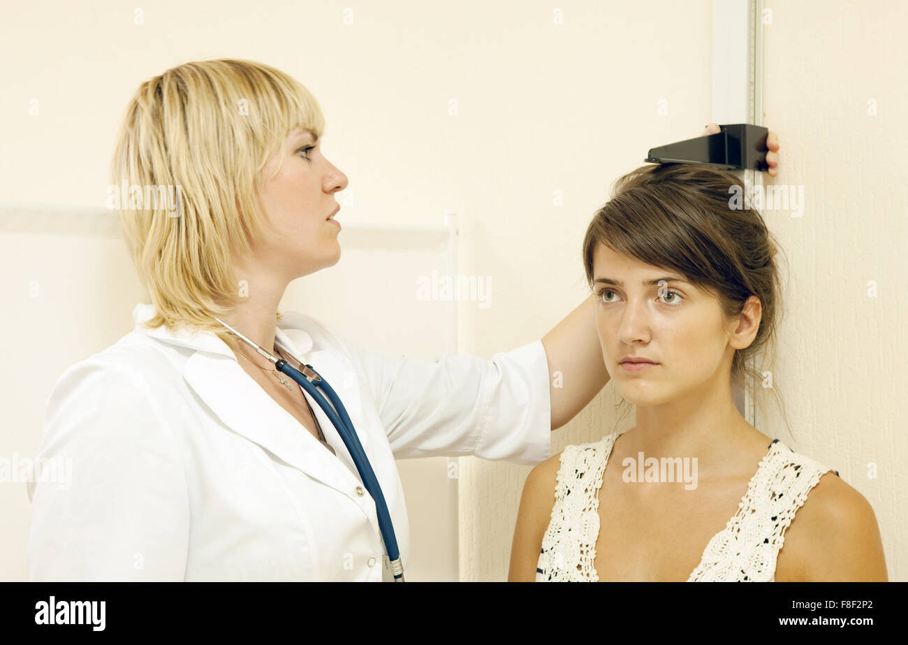 Frau, die Messung der Höhe von Jugendlicher Patient in Klinik Stockfoto
