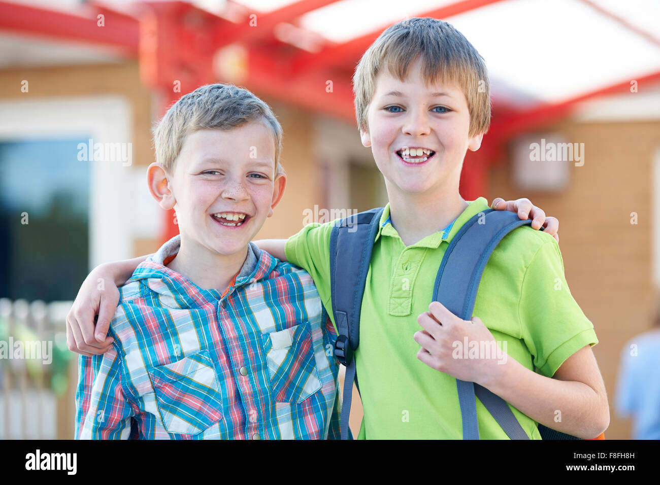Zwei jungen stehen außerhalb der Schule mit Schultaschen Stockfoto