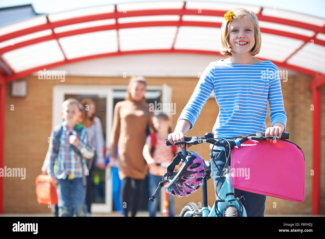 Weibliche Schüler drängen Bike am Ende des Schultages Stockfoto