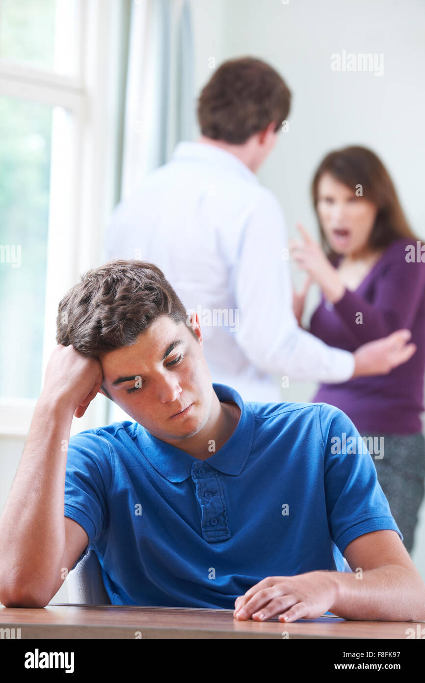 Unglückliche Teenager mit Eltern streiten im Hintergrund Stockfoto