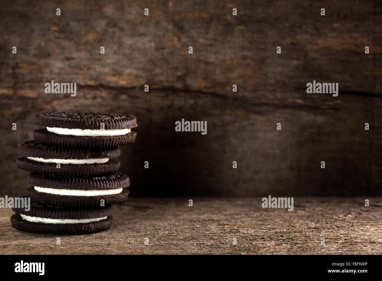 Schokoladen-Cookies mit weißer Füllung sind auf Holztisch Stockfoto
