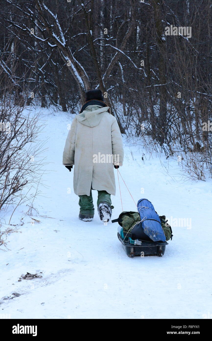 Fischer zu Fuß mit Ausrüstungen auf Schnee Stockfoto