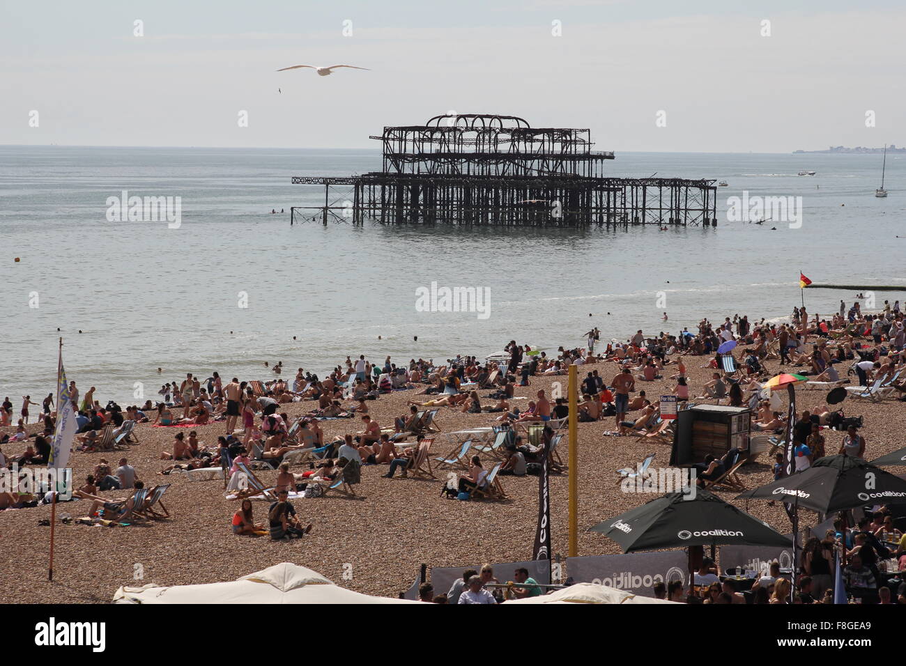 Strand von Brighton mit niedergebrannt Pier West im Hintergrund Stockfoto