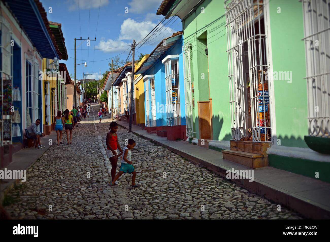 Kinder spielen auf einer gepflasterten Straße, gesäumt von bunten Häusern in Trinidad Provinz Sancti Spiritus-Kuba Stockfoto