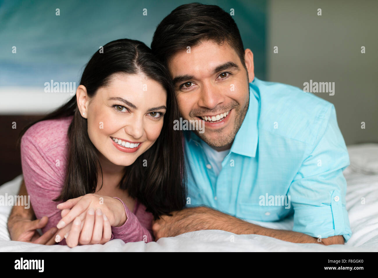 Hispanische paar lächelnd auf Bett Stockfoto