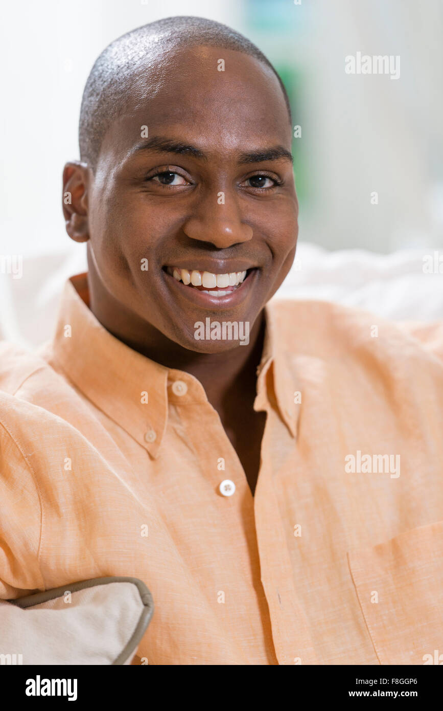 Schwarzer Mann lächelnd im Innenbereich Stockfoto