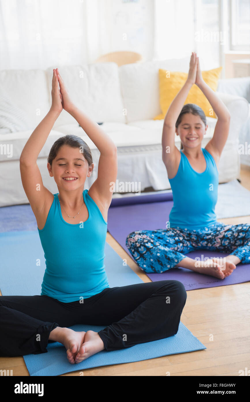 Kaukasische Zwillingsschwestern, Yoga zu praktizieren Stockfoto