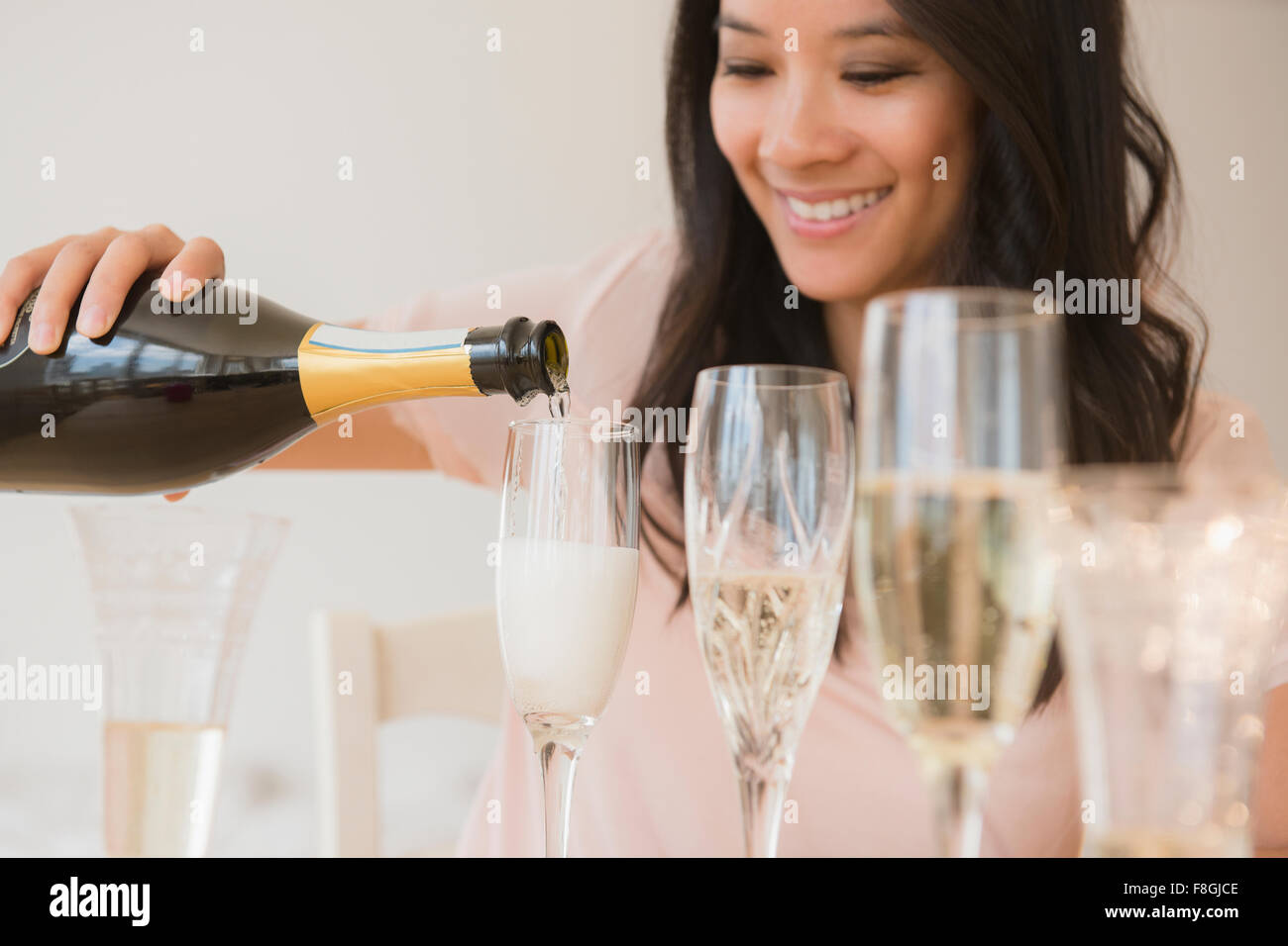 Chinesische Frau gießt Champagner Stockfoto