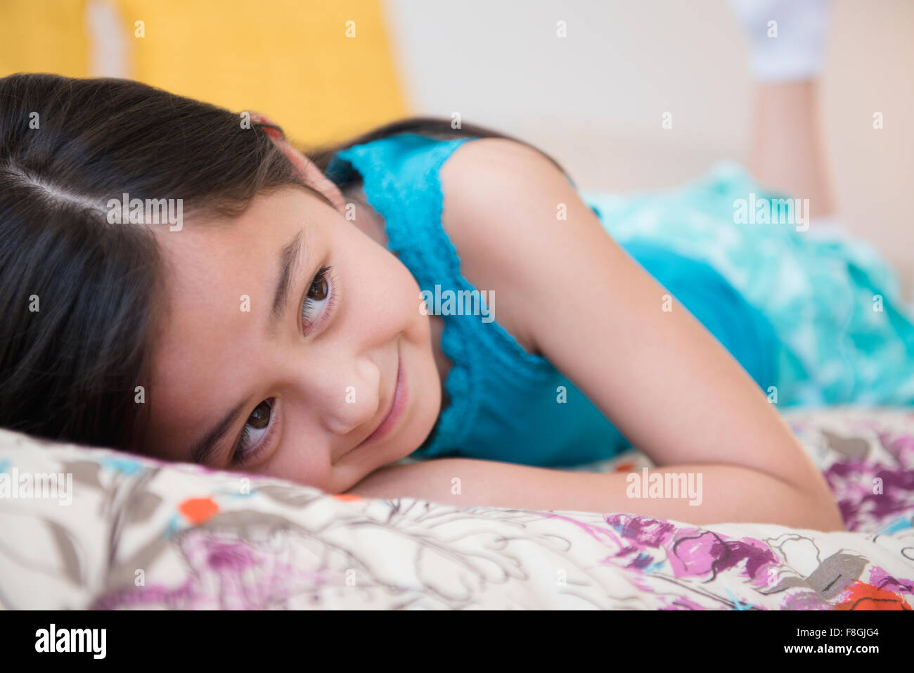Lächelndes Mädchen auf Bett Stockfoto