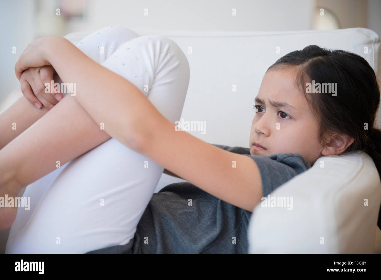 Böse Mädchen schmollend auf sofa Stockfoto