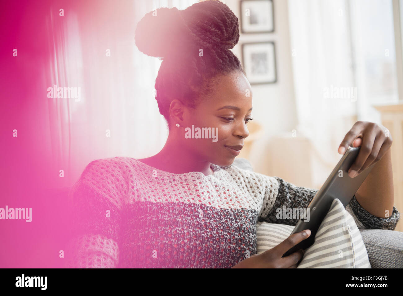 Schwarze Frau mit digital-Tablette auf sofa Stockfoto