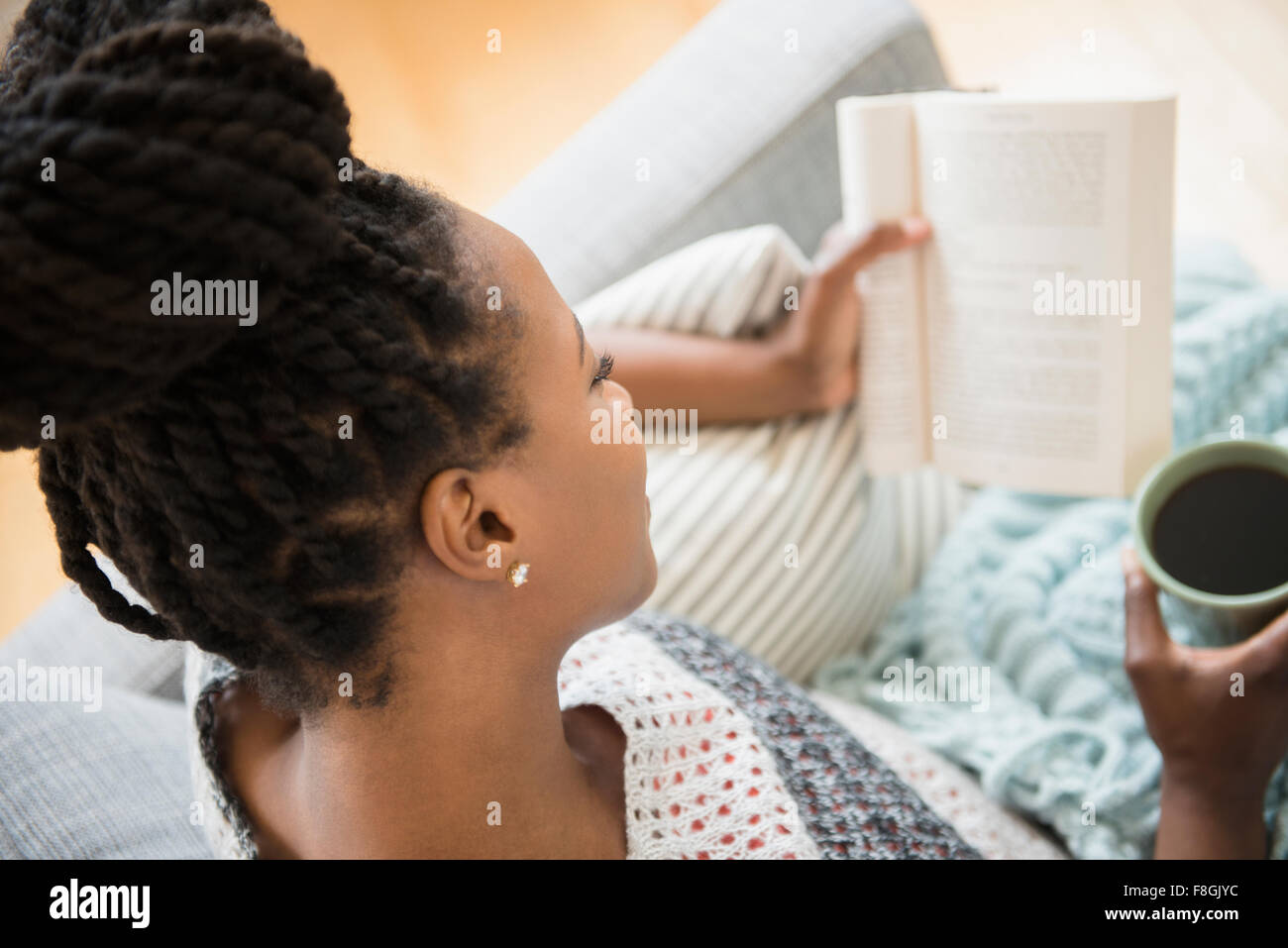 Schwarze Frau Buch lesen und Kaffee trinken Stockfoto