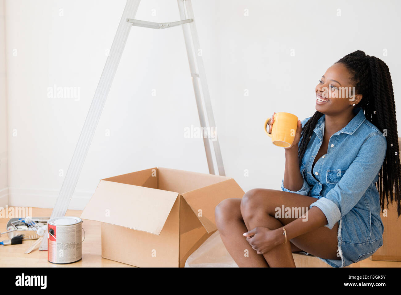 Schwarze Frau Kaffeetrinken im neuen Zuhause Stockfoto