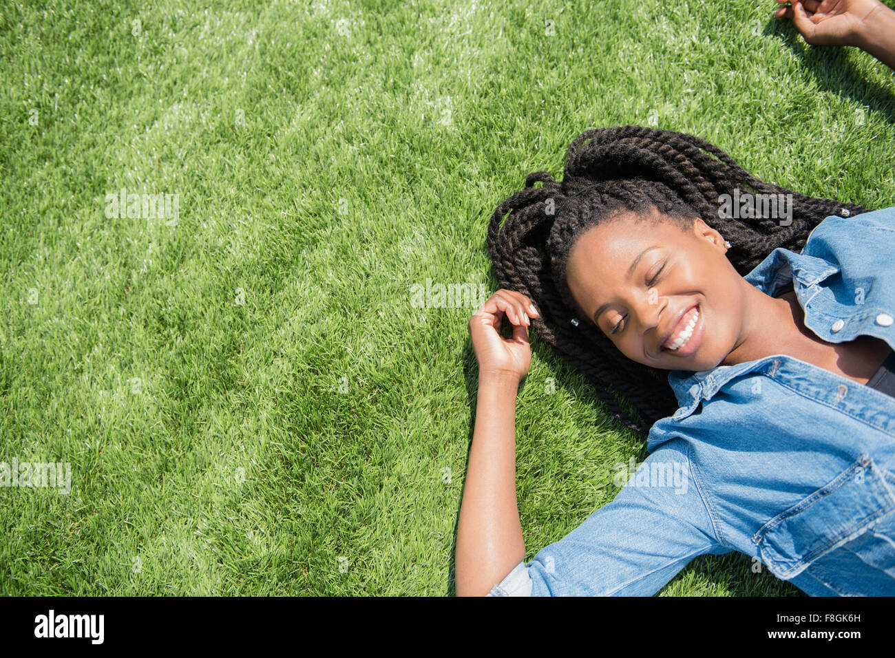 Schwarze Frau, die Verlegung in Rasen Stockfoto