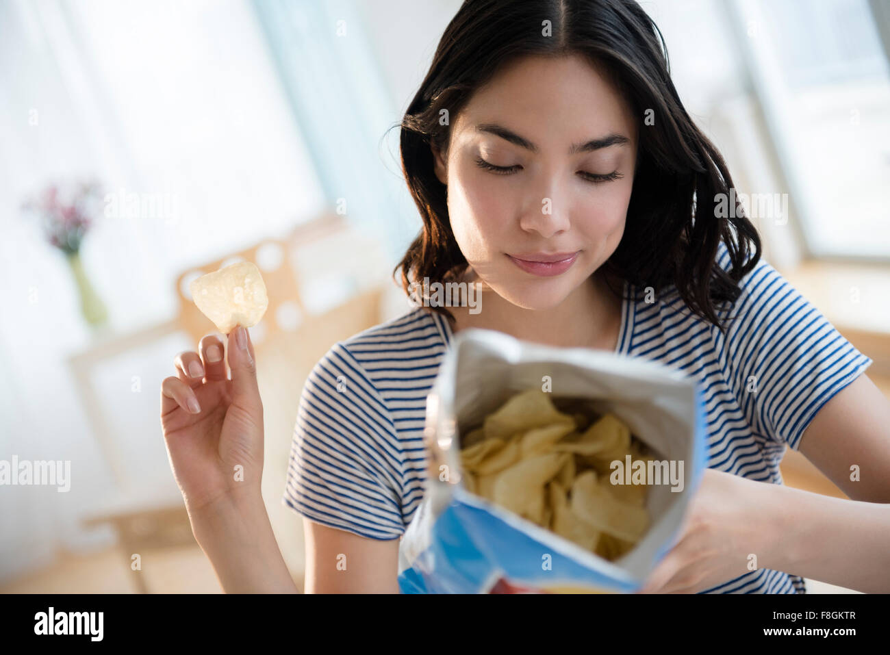 Hispanic Frau lesen Zutaten auf Beutel der Kartoffelchips Stockfoto