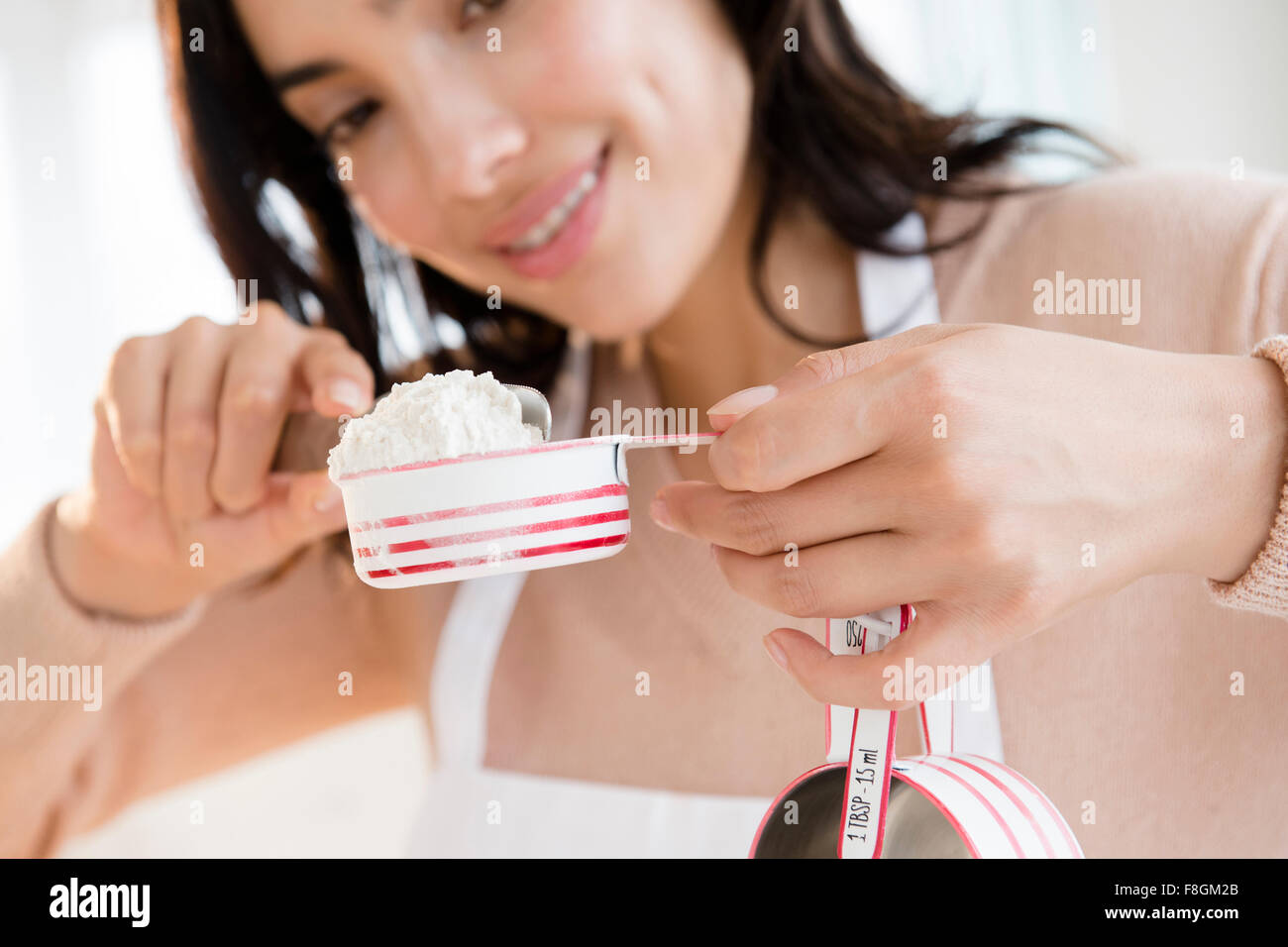 Hispanic Frau Mehl messen Stockfoto