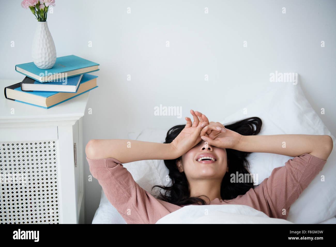 Hispanic Frau aufwachen im Bett Stockfoto