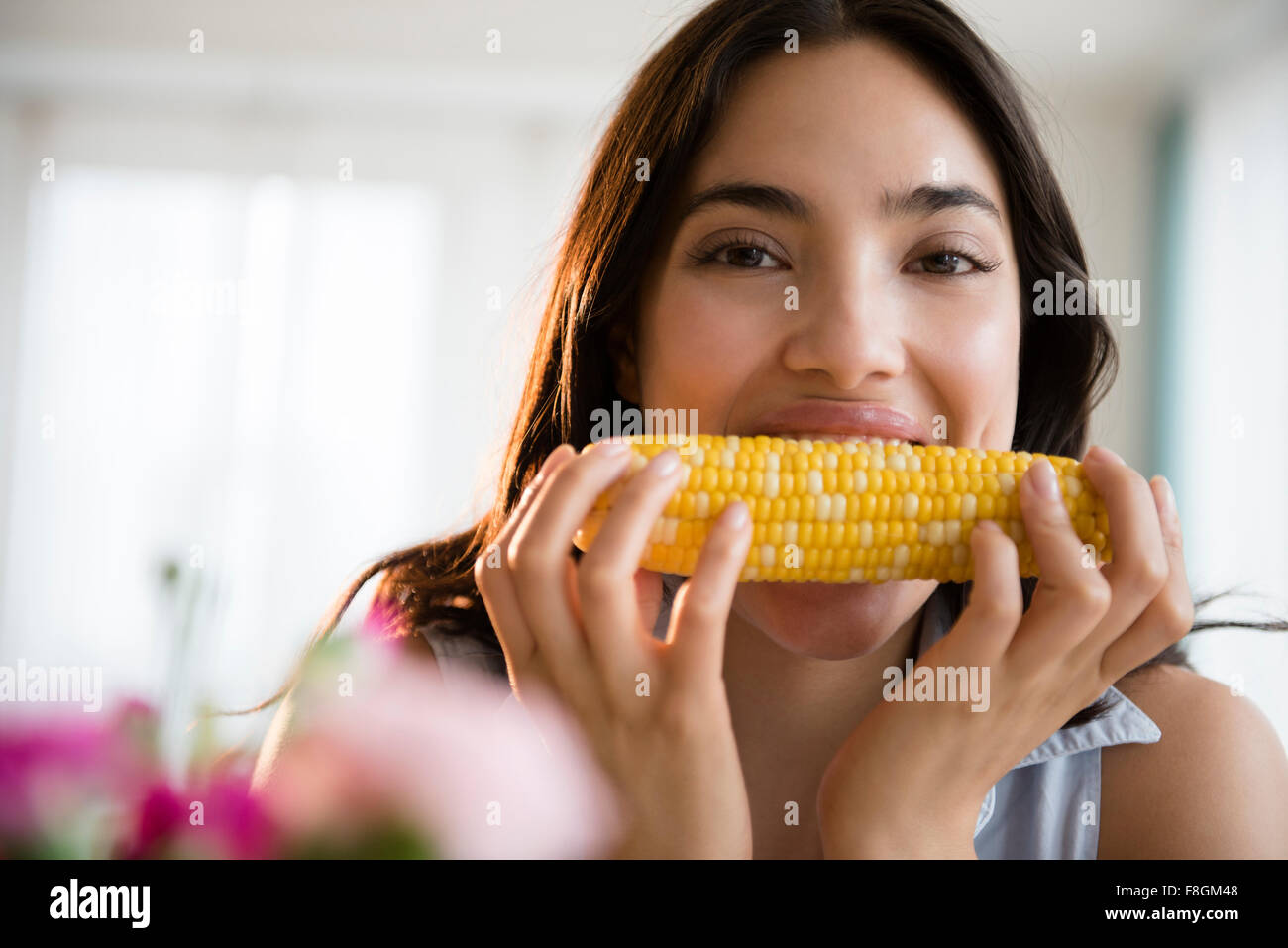 Hispanic Frau Essen Mais Maiskolben Stockfoto