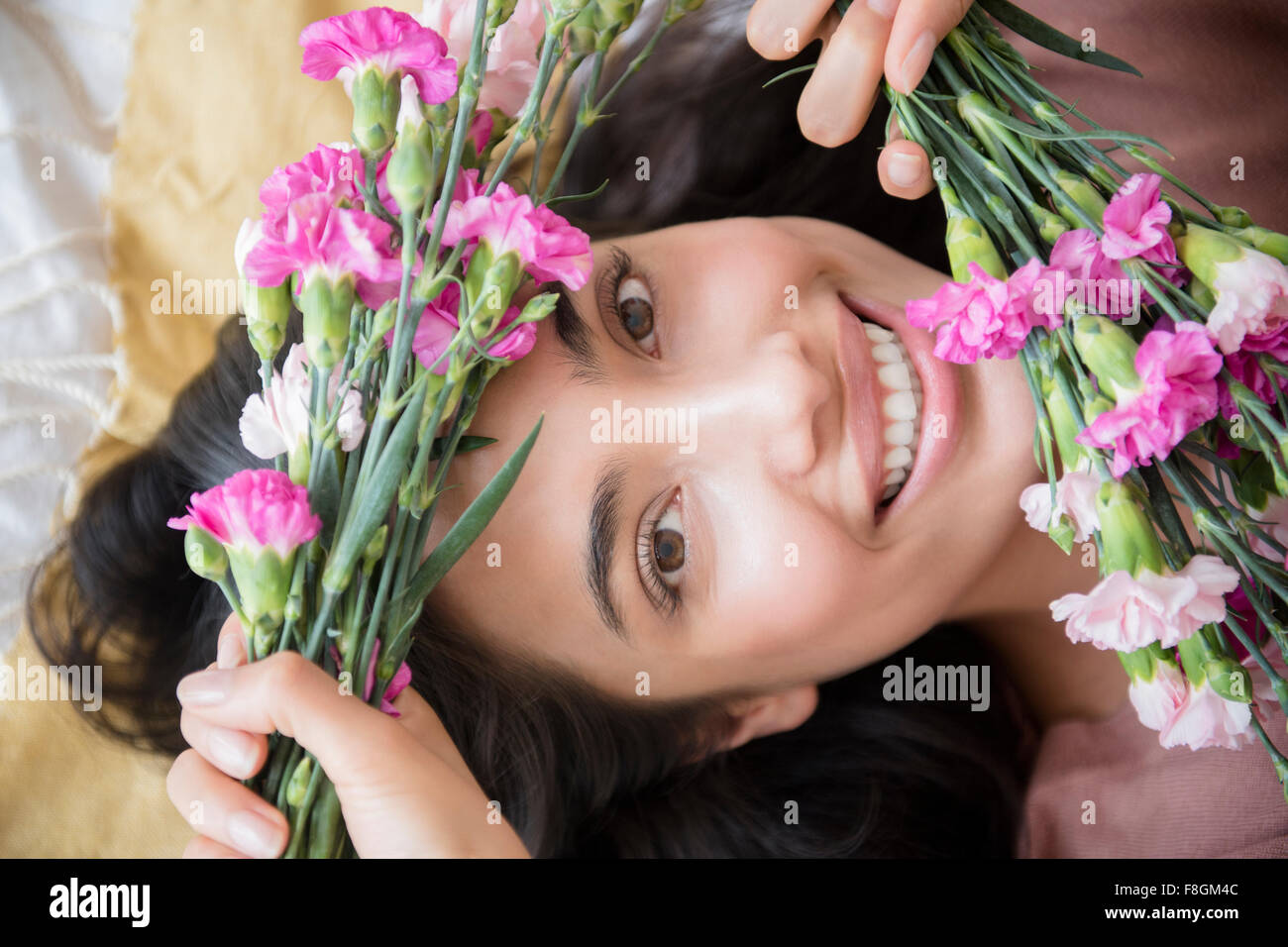 Hispanic Frau halten Blumen Stockfoto