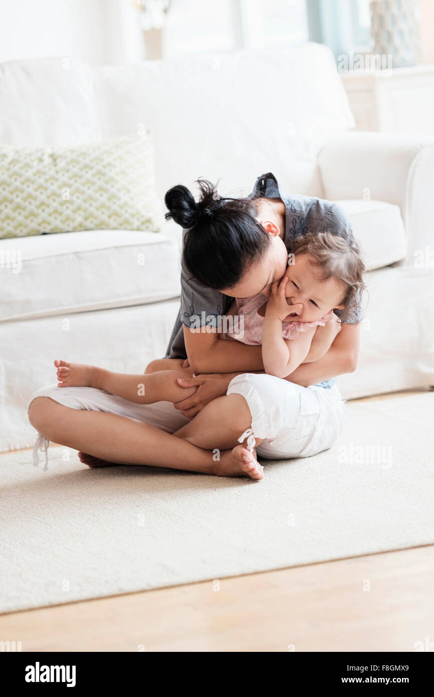 Mutter und Baby Tochter spielen im Wohnzimmer Stockfoto