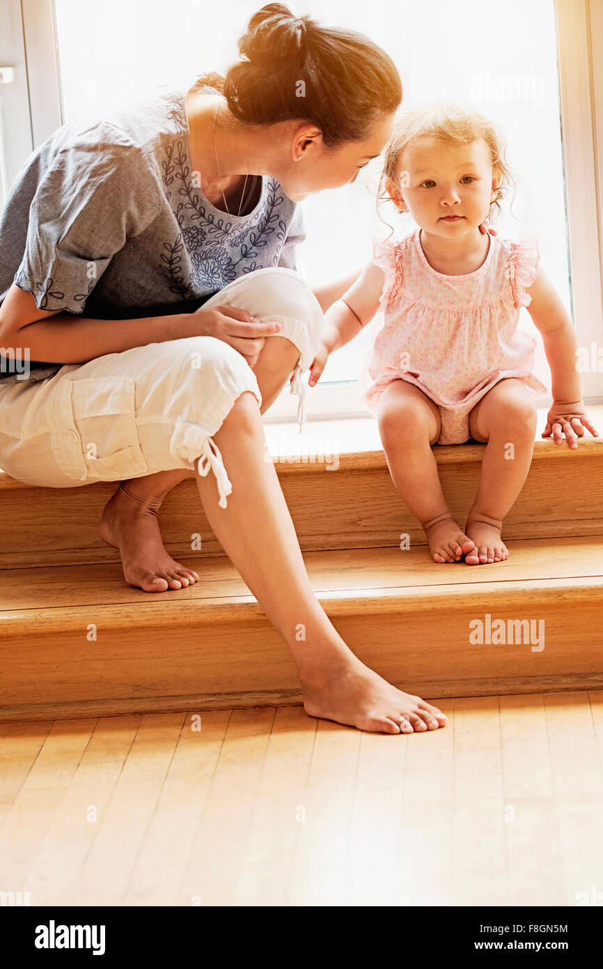 Mutter und Baby Tochter sitzen auf Stufen Stockfoto