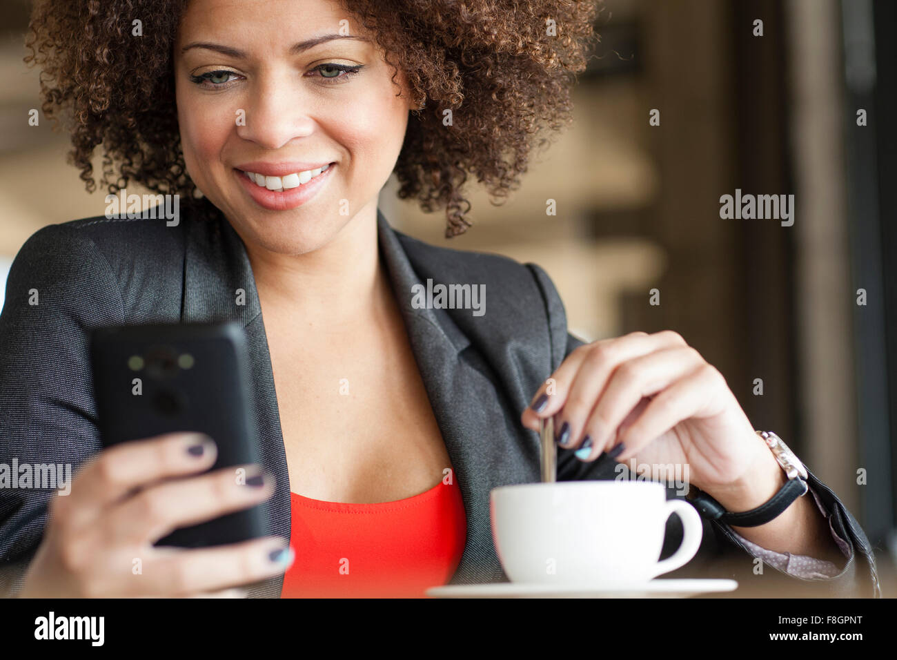 Gemischte Rassen Frau mit Handy im café Stockfoto