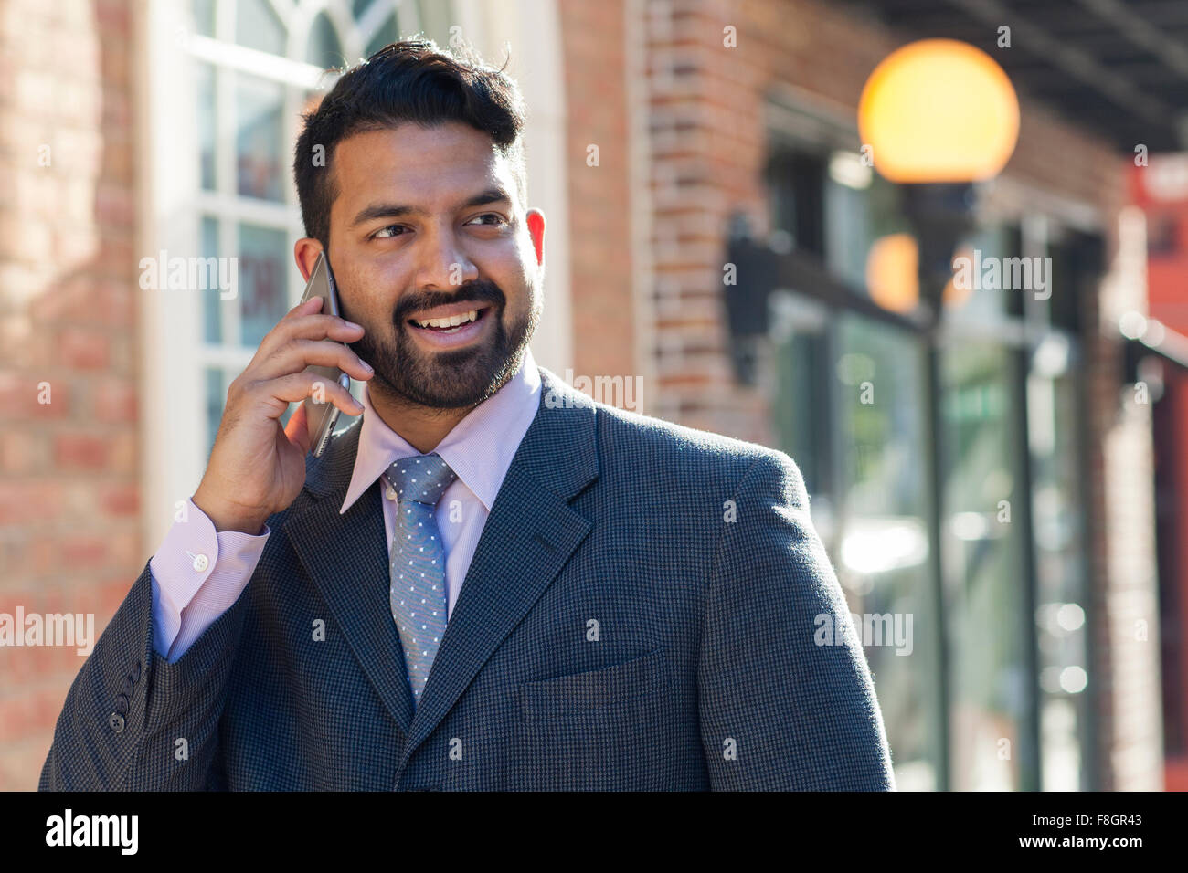 Indischer Geschäftsmann reden über Handy in Stadt Stockfoto