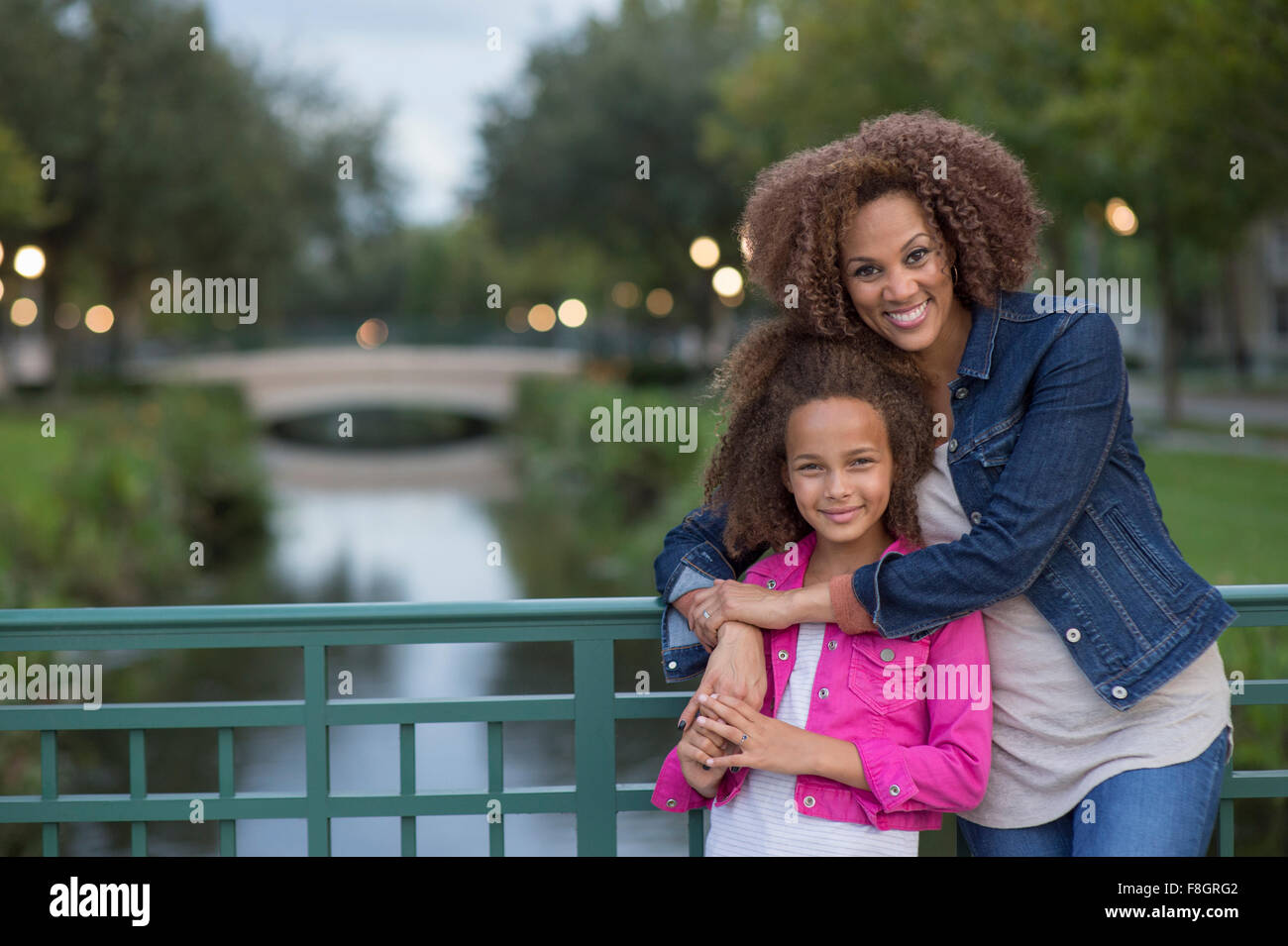 Mischlinge Mutter und Tochter umarmt auf Brücke Stockfoto