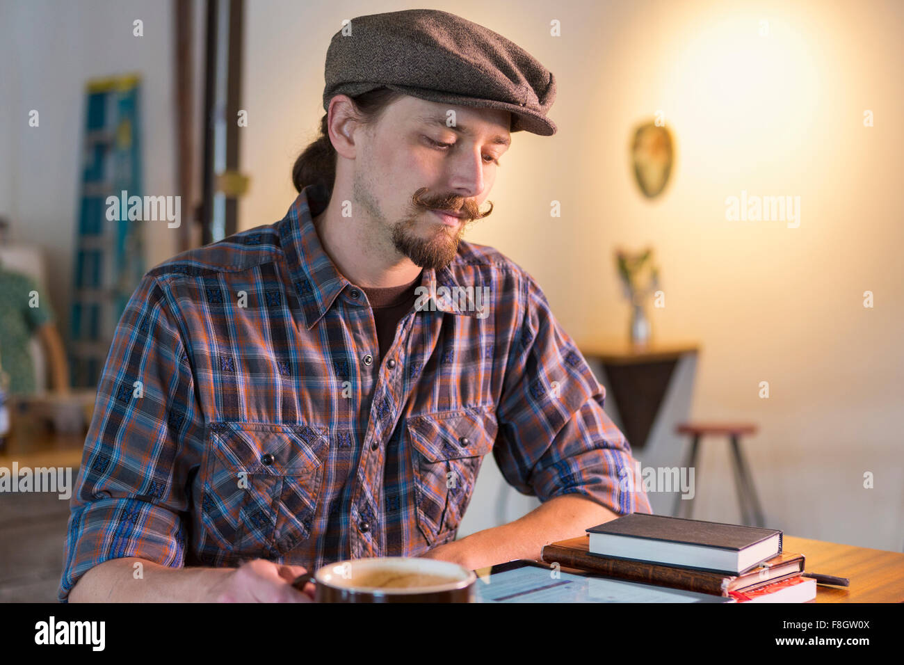 Kaukasischen Mann liest im café Stockfoto