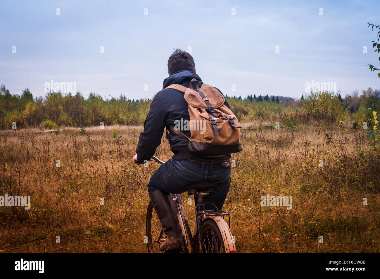 Kaukasischen Mann Reiten Fahrrad im Feld Stockfoto