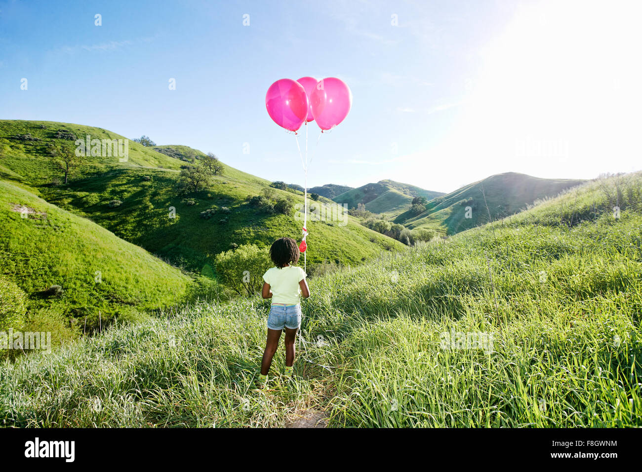 Schwarze Mädchen mit Luftballons auf ländlichen Hügel Stockfoto