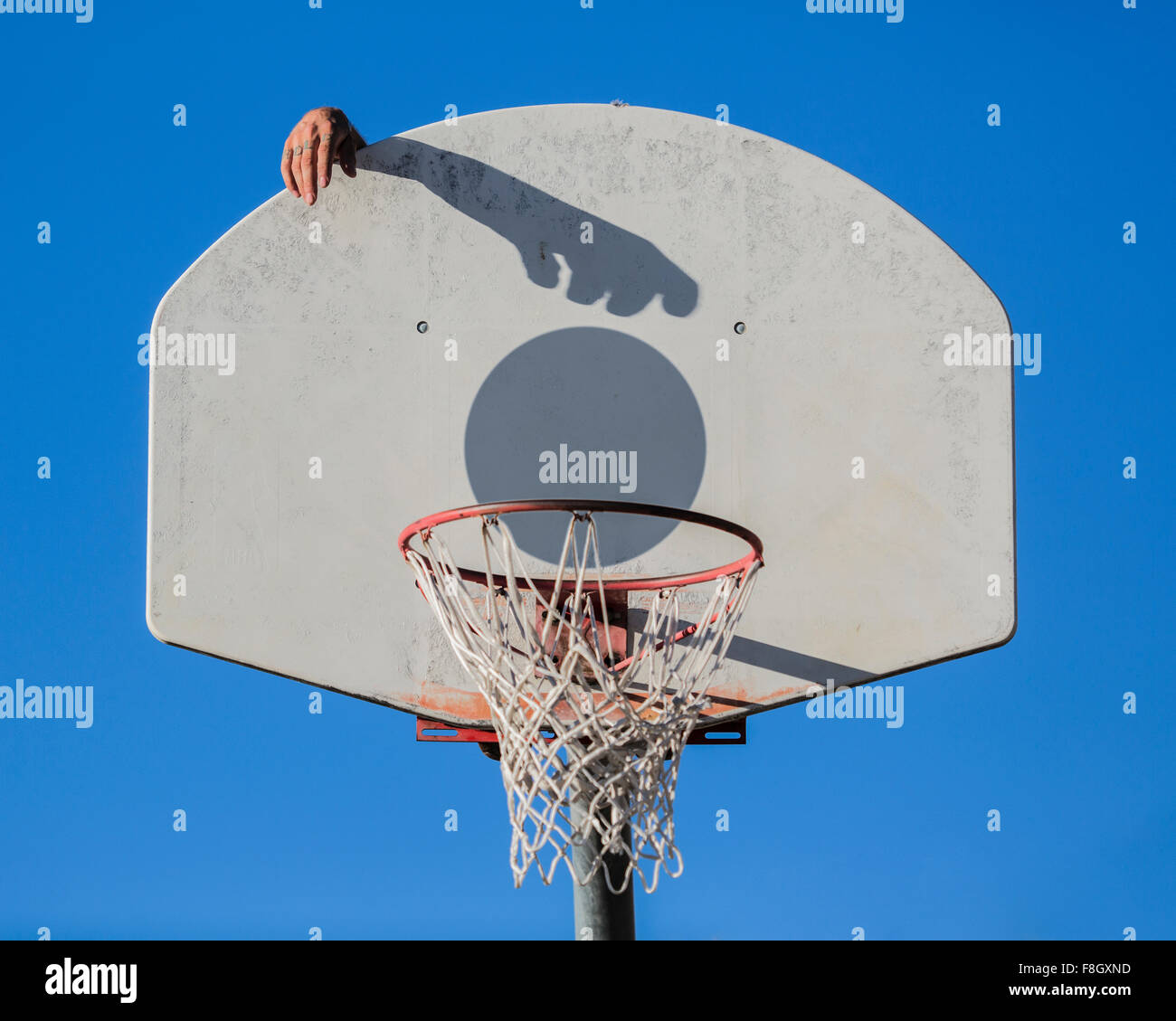 Kaukasischen Mann dunking Basketball Schatten in Reifen Stockfoto