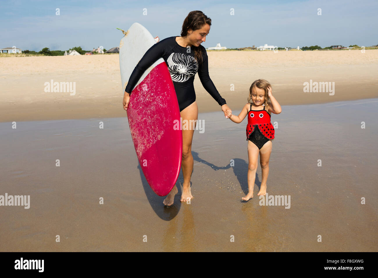 Tochter Mutter Lehre im Meer Surfen Stockfoto