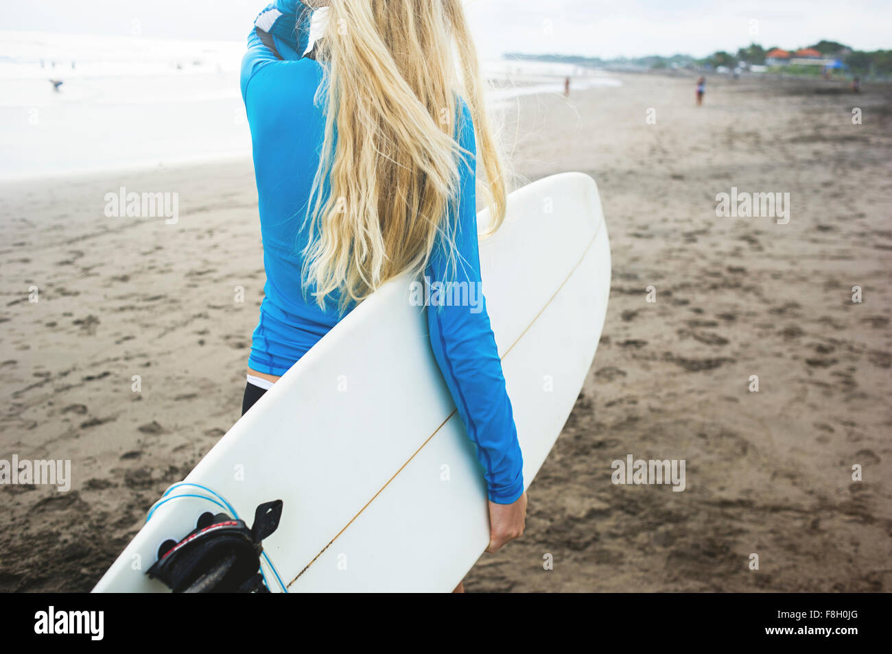 Kaukasische Surfer mit Surfbrett am Strand Stockfoto