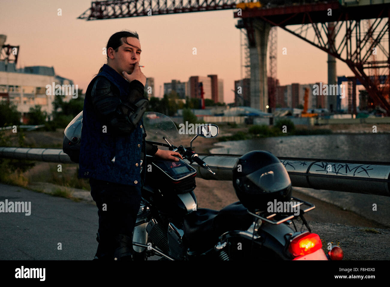 Kaukasischen Mann Rauchen in der Nähe von Motorrad Stockfoto