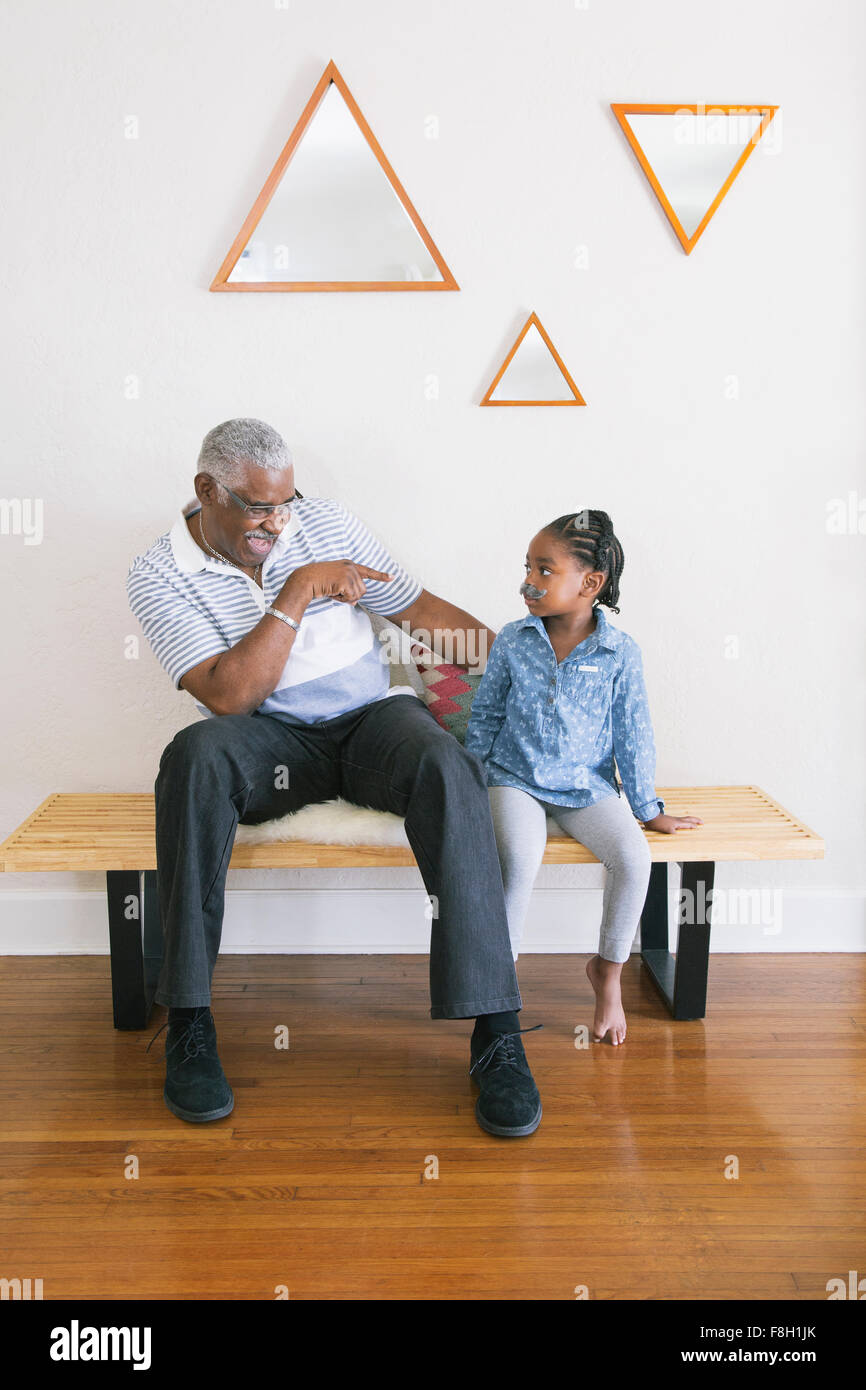 African American Großvater zeigte auf Enkelin auf Bank Stockfoto