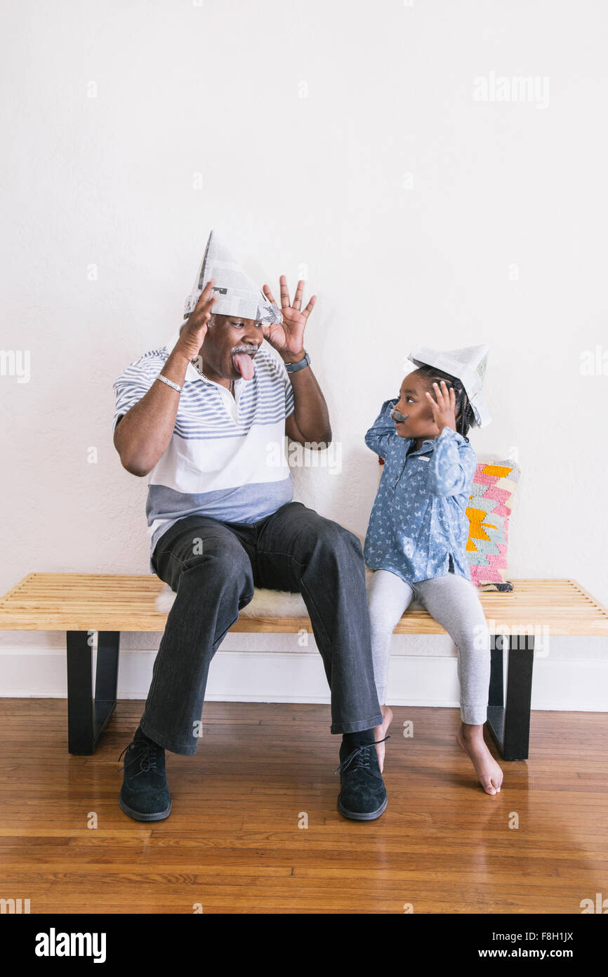 African American Großvater und Enkelin spielen auf Bank Stockfoto