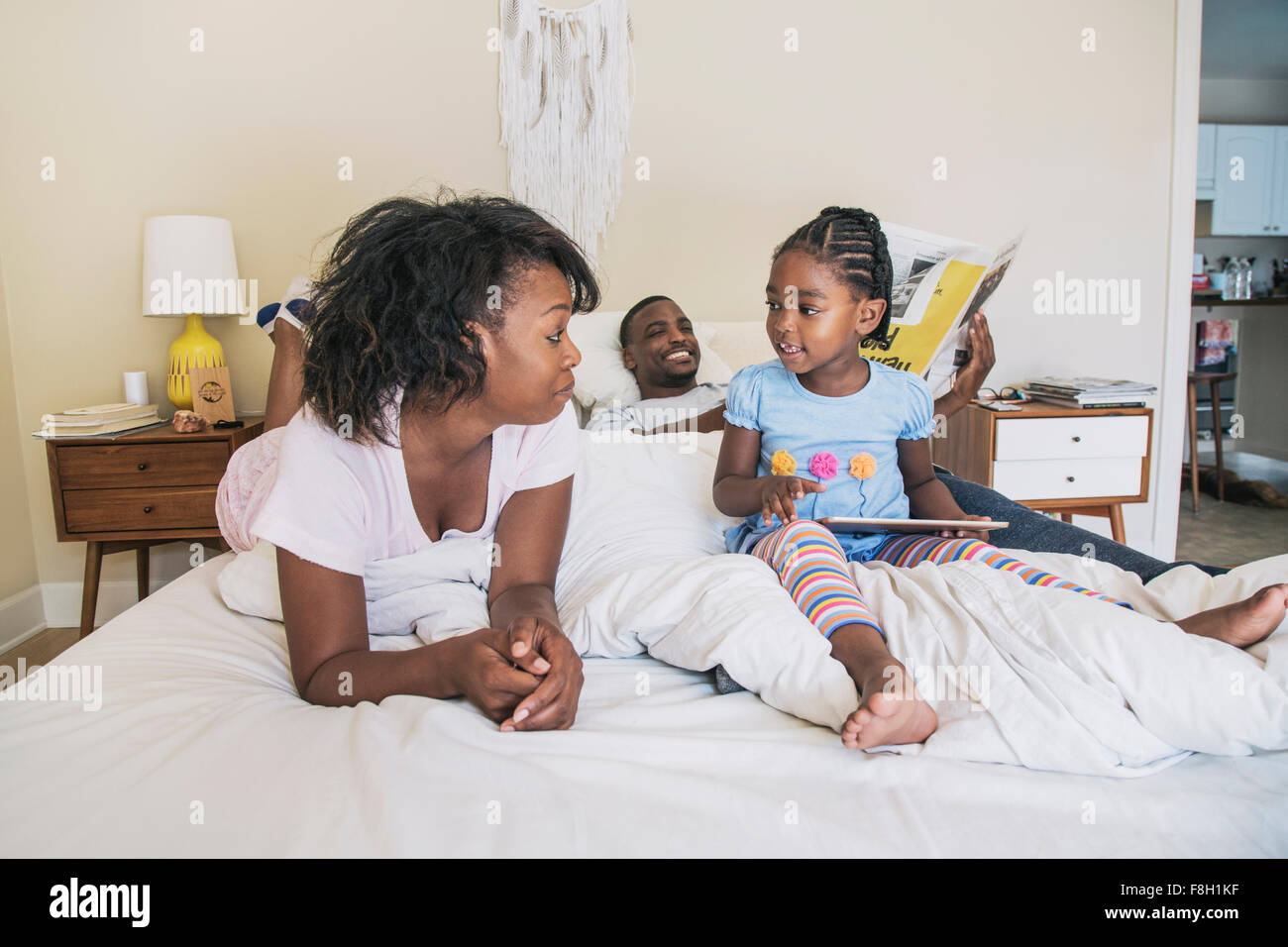 Afrikanische amerikanische Eltern und Tochter am Bett Stockfoto