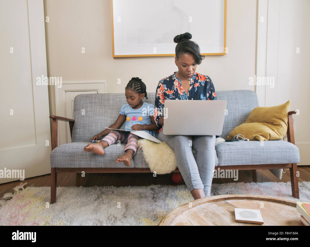 African American Mutter und Tochter im Wohnzimmer entspannen Stockfoto