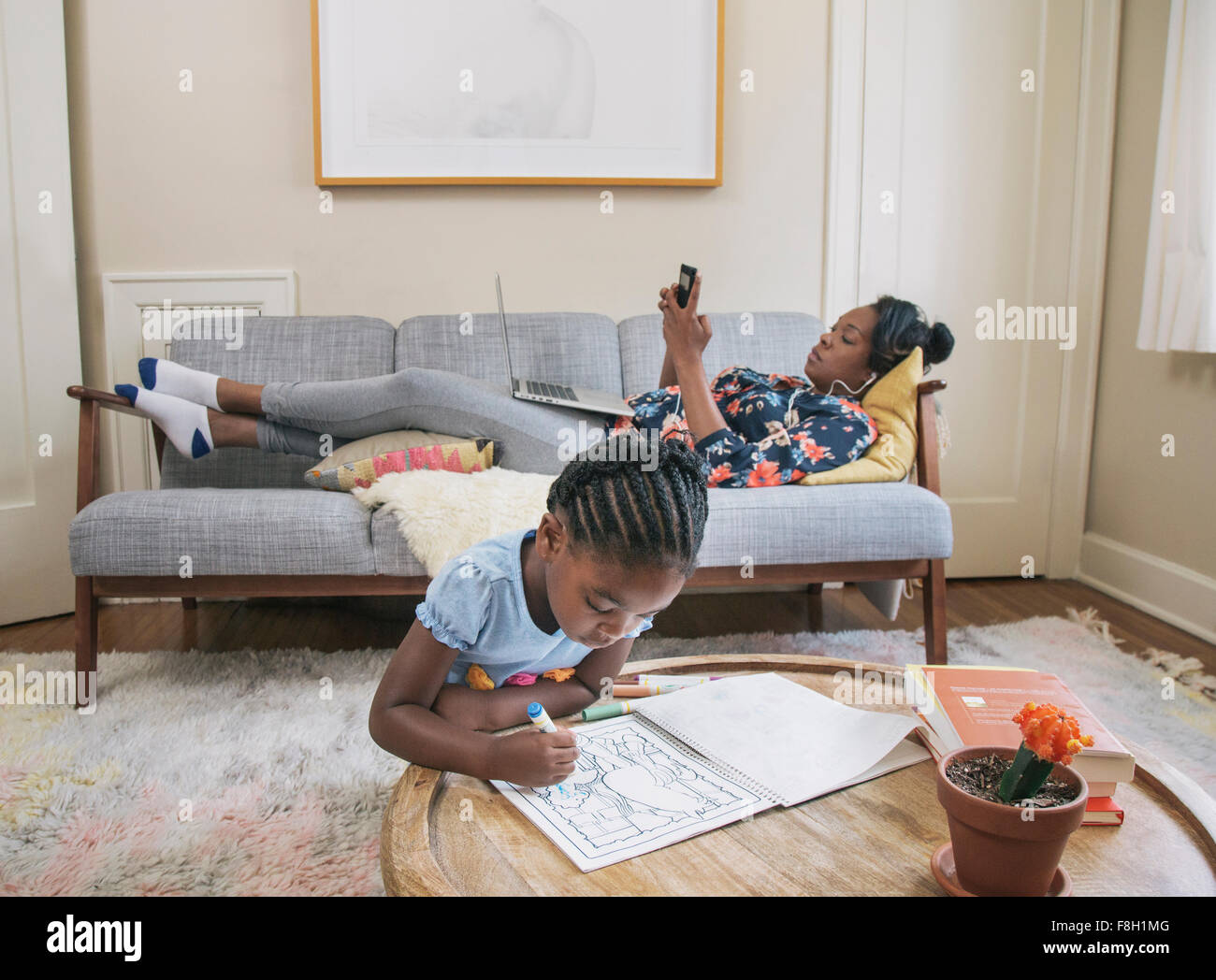 African American Mutter und Tochter im Wohnzimmer entspannen Stockfoto