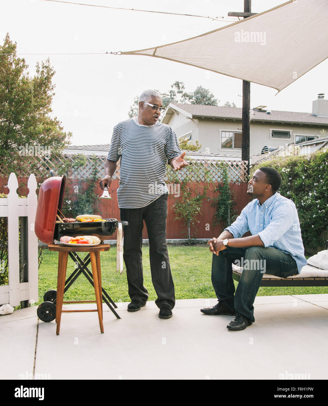 Afroamerikanischen Vater und Sohn am Grill im Gespräch Stockfoto