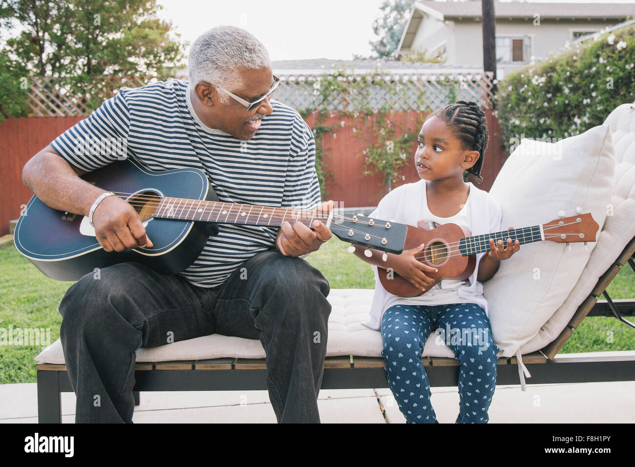 African American Großvater Lehre Enkelin, Gitarre zu spielen Stockfoto